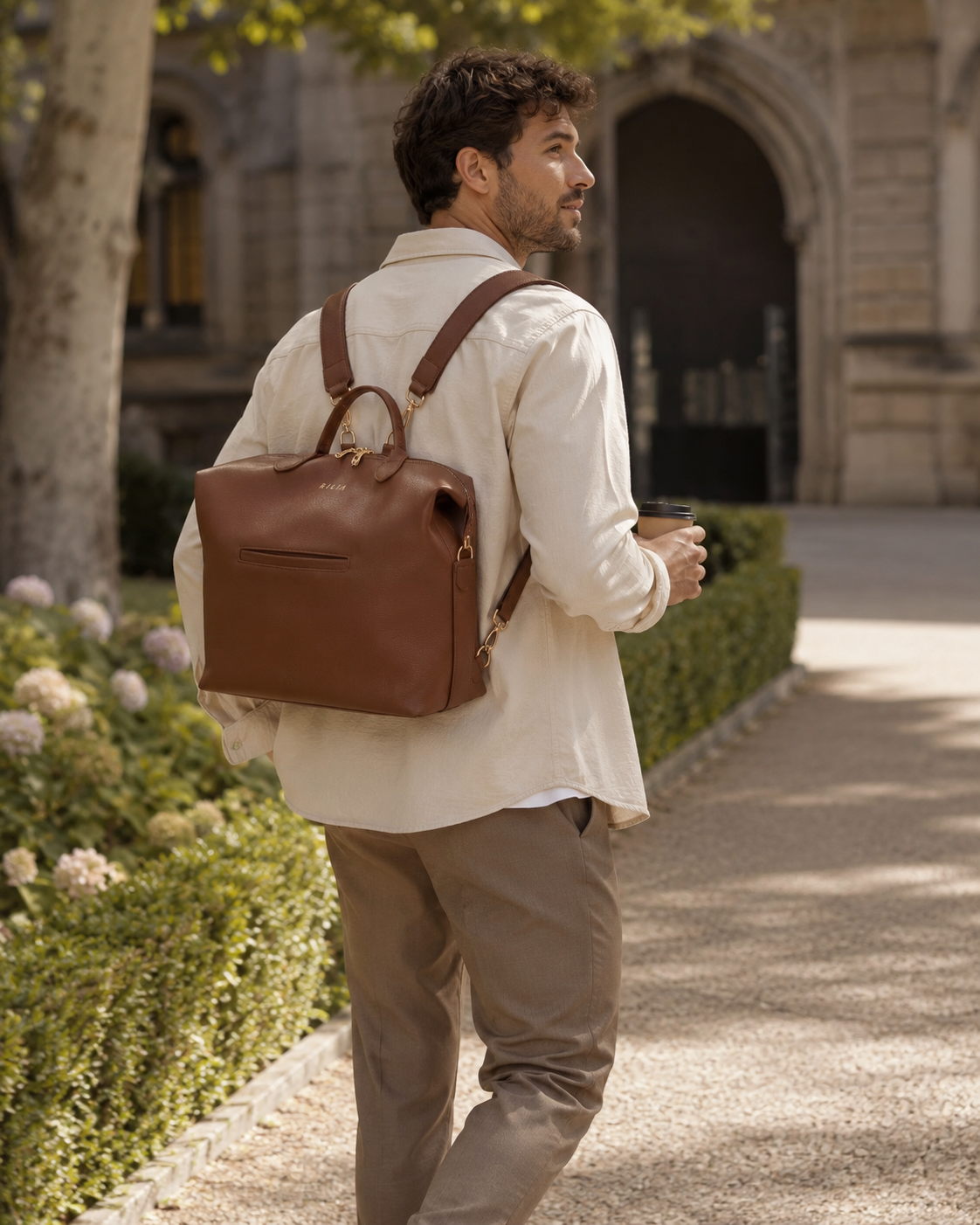 Mann trägt die RILIA Signature Bag als Rucksack auf dem Weg durch einen Park