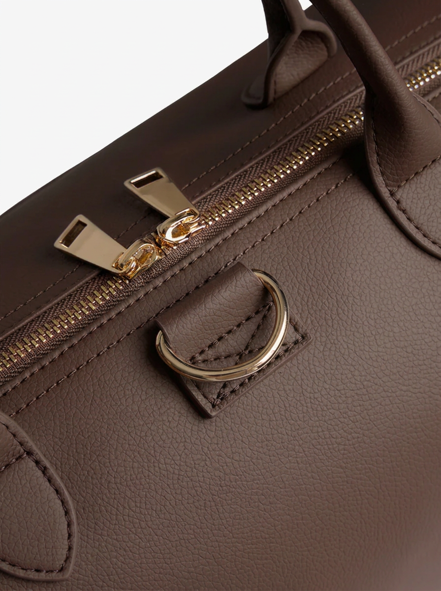 Nahaufnahme der Gold-Hardware und Naht der RILIA Signature Bag
